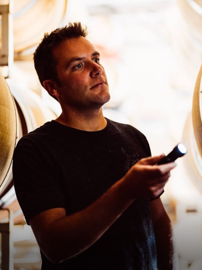 Winemaker Anthony Yount inspecting barrels with a flashlight