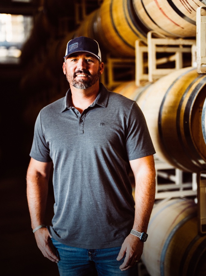 Vineyard manager Kevin Wilkinson standing among barrel stacks