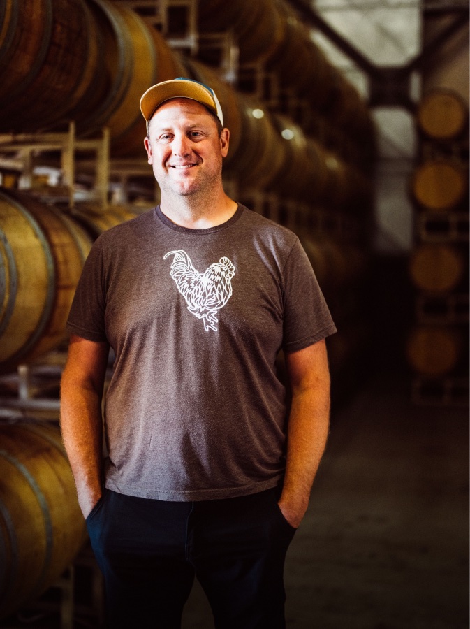 Vintner Juan Mercado holding a wine thief and glass in the cellar